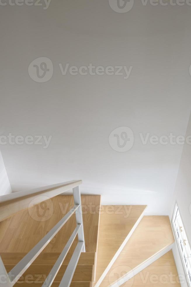 l'escalier en bois incurvé moderne avec la main courante en métal blanc. photo