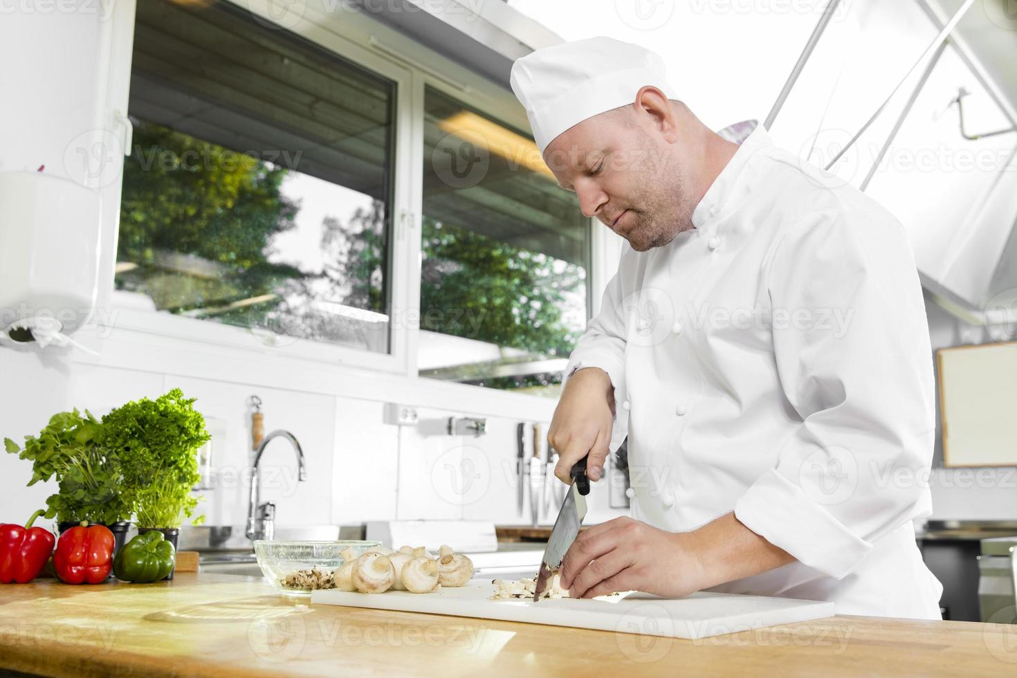 Chef professionnel préparant des légumes dans une grande cuisine photo