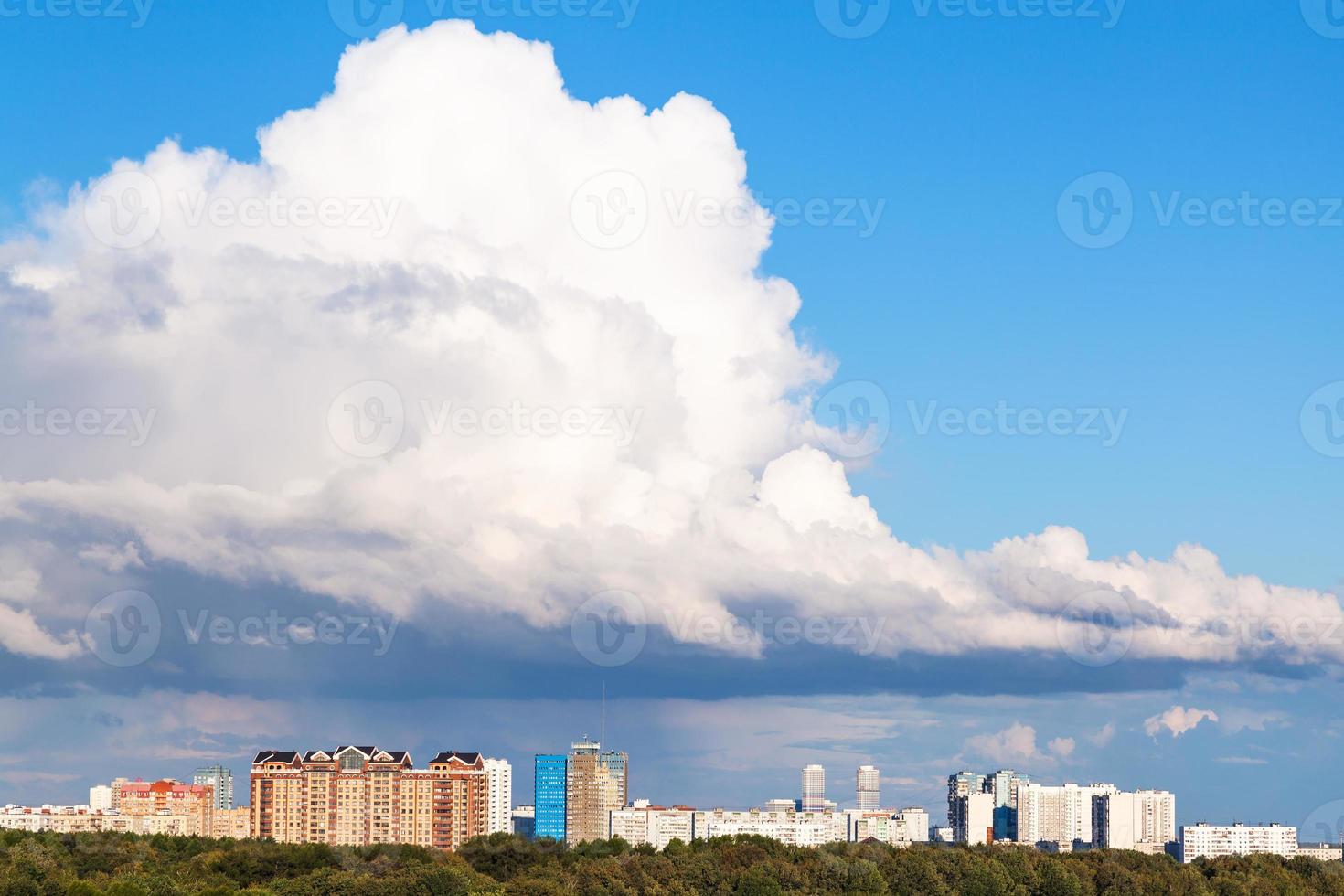 grand nuage blanc bas dans le ciel bleu au-dessus de la ville photo