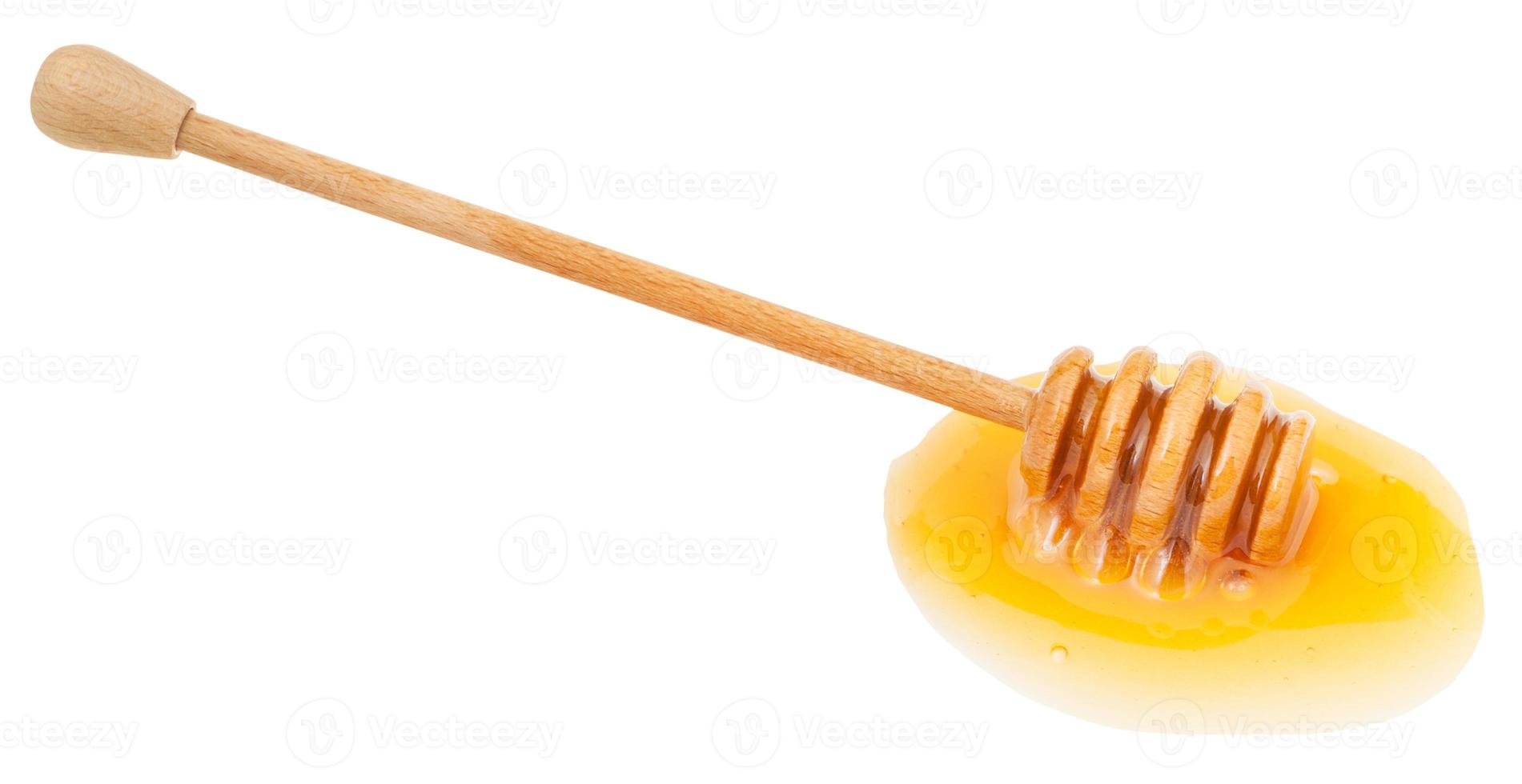 flaque de miel transparent et bâton en bois photo