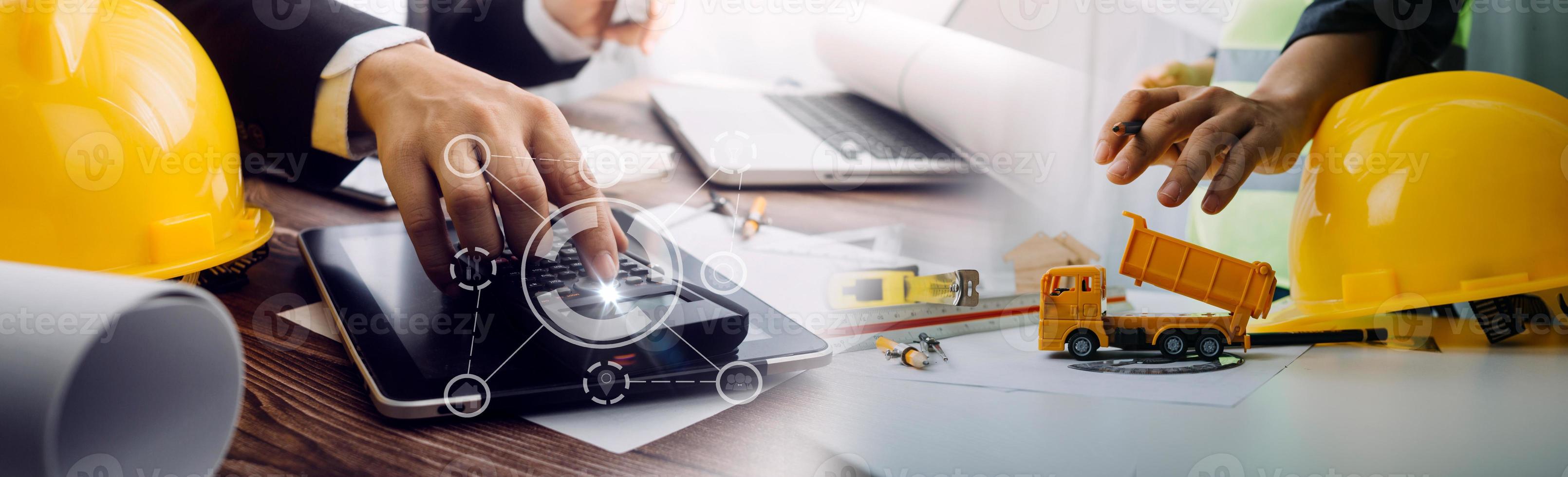 Deux collègues discutant des données de travail et tablette, ordinateur portable avec sur le projet architectural sur le chantier de construction au bureau au bureau photo