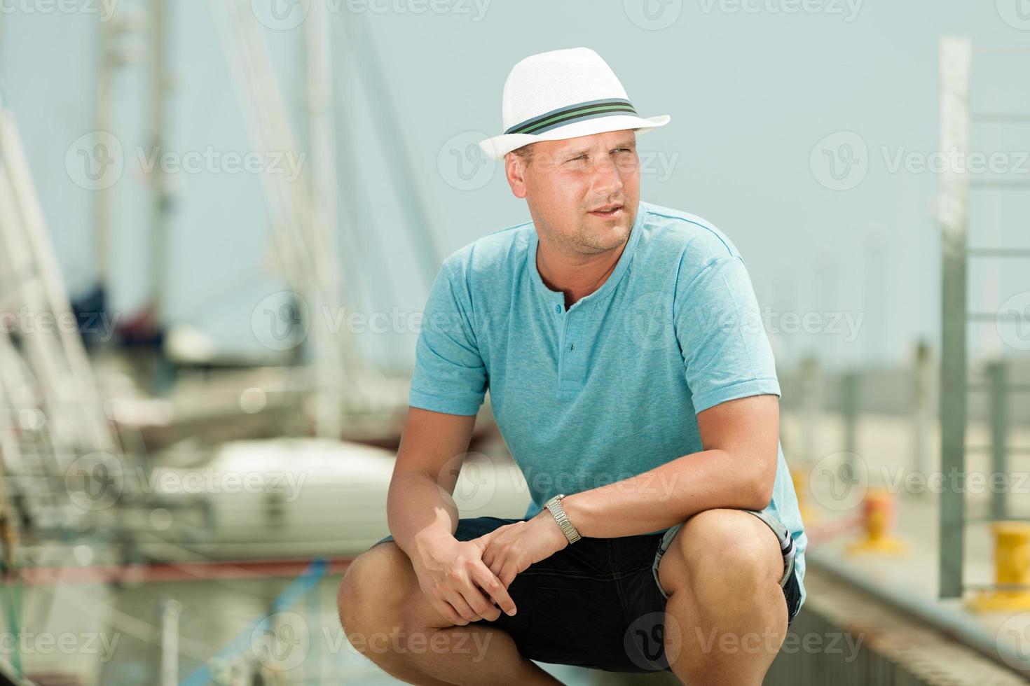 Mode portrait de bel homme sur la jetée contre les yachts photo