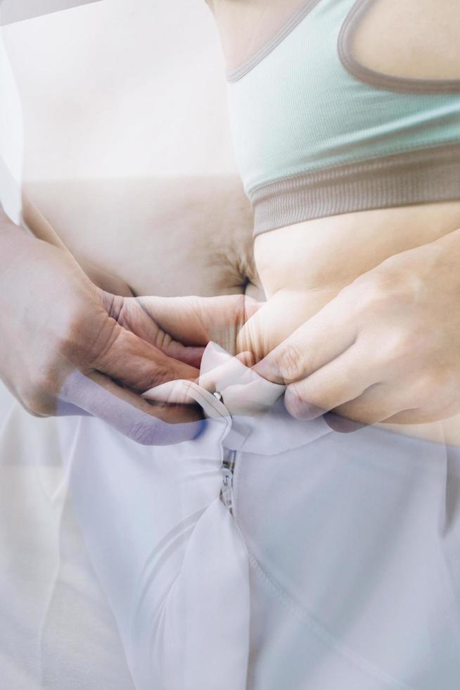 belle grosse femme avec ruban à mesurer, elle utilise sa main pour presser l'excès de graisse isolé sur fond blanc. elle veut perdre du poids, le concept de chirurgie et décomposer les graisses sous le photo