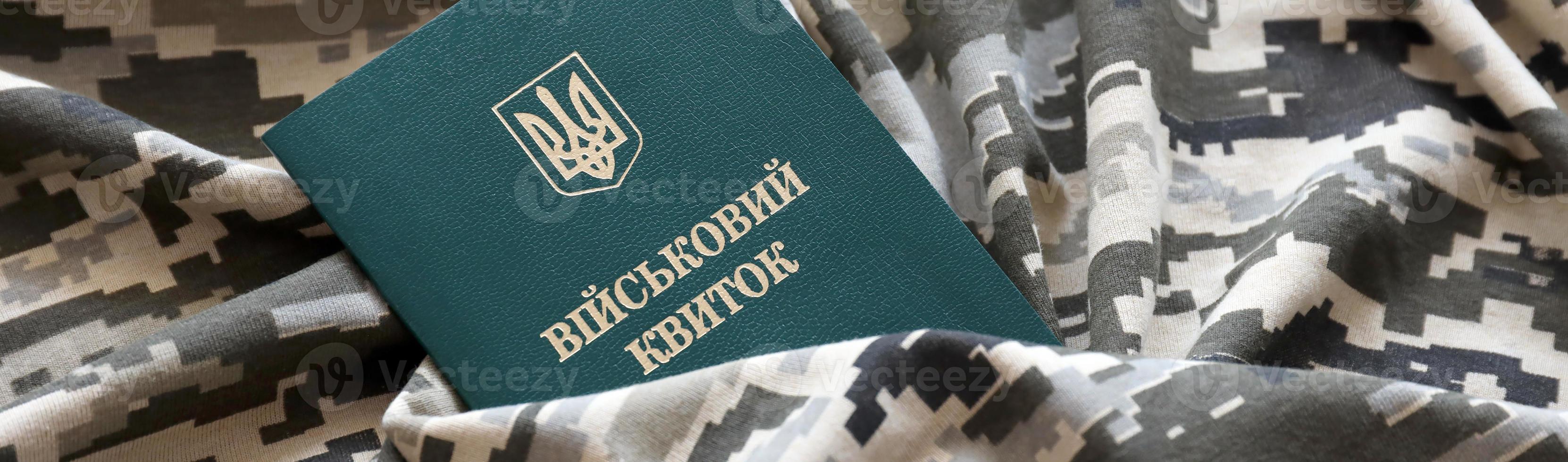 carte d'identité militaire ukrainienne sur tissu avec texture de camouflage pixélisé. tissu avec motif camouflage en formes de pixels gris, marron et vert avec jeton personnel de l'armée ukrainienne photo