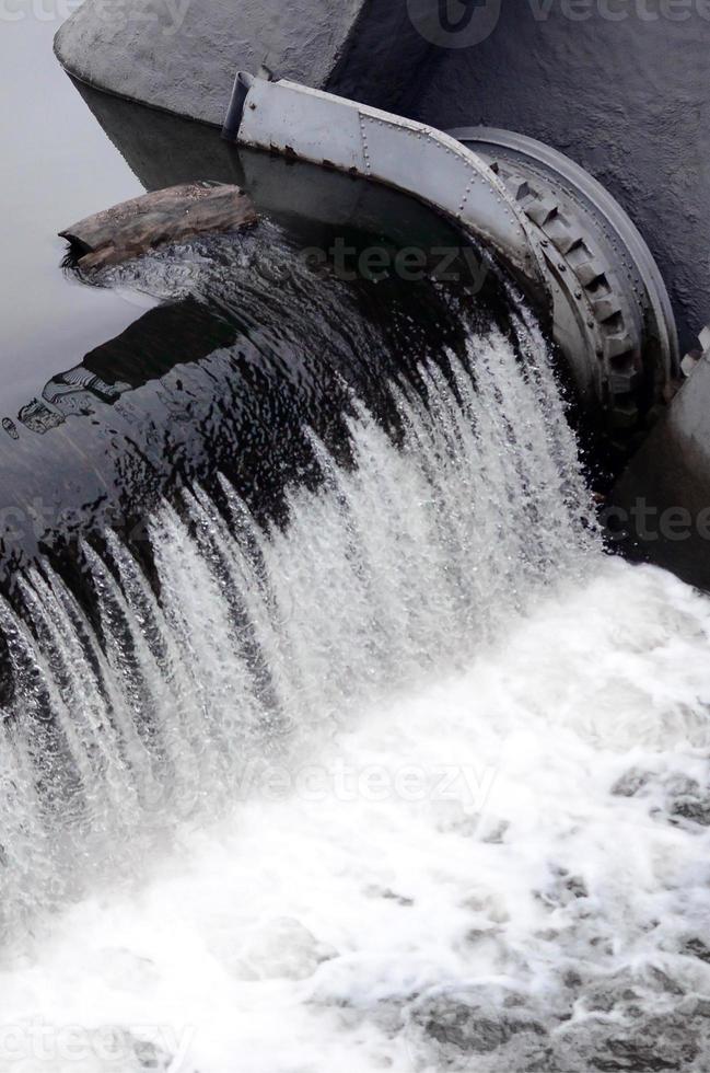 une image de l'eau qui coule. le barrage est conçu pour réguler le niveau d'eau dans les rivières de la ville et pour fournir de l'eau technique aux objets industriels photo