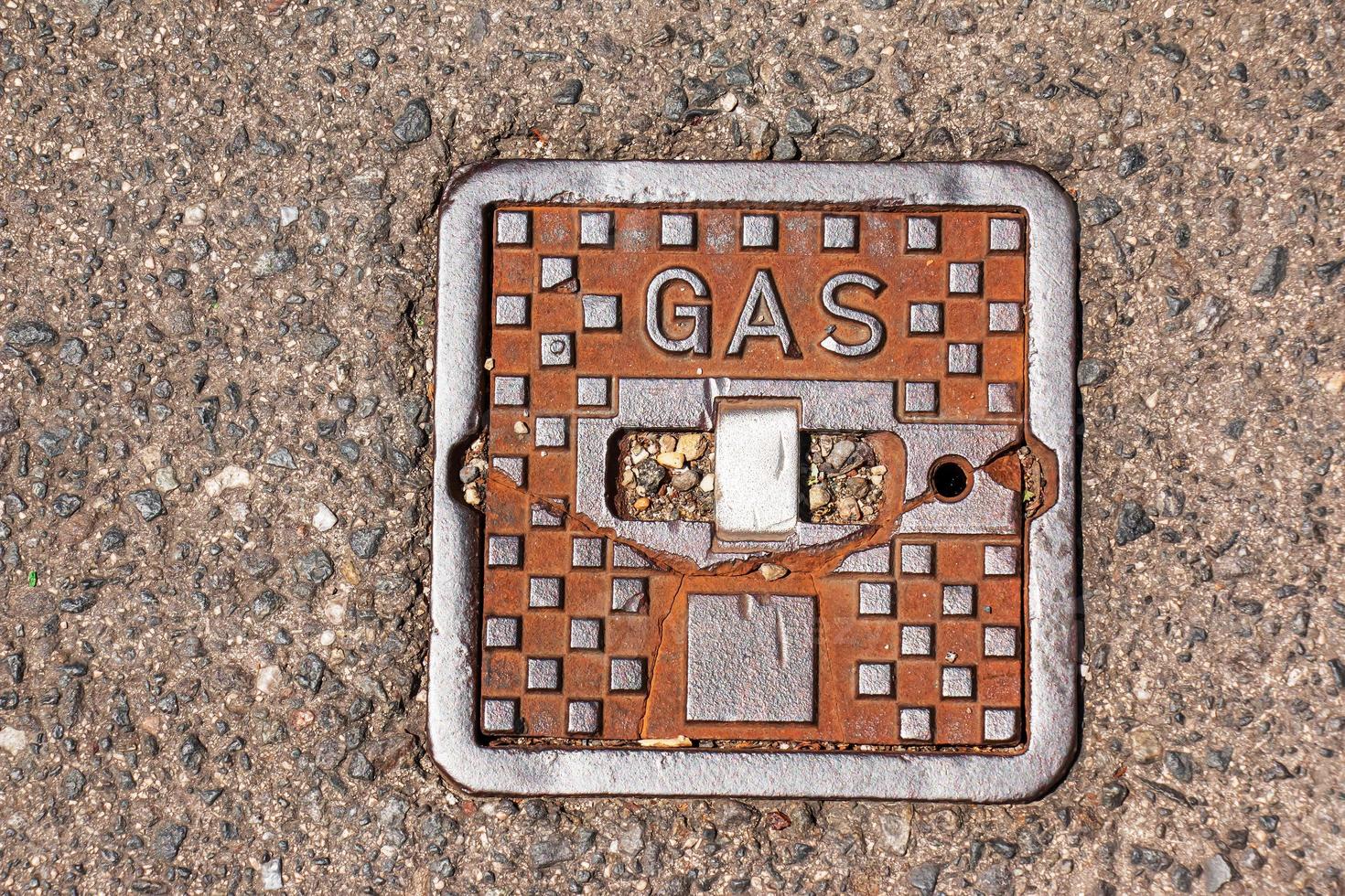 couvercle de trou d'homme du système de gazoduc. une trappe métallique massive pour l'accès aux communications de la ville dans le trottoir. photo