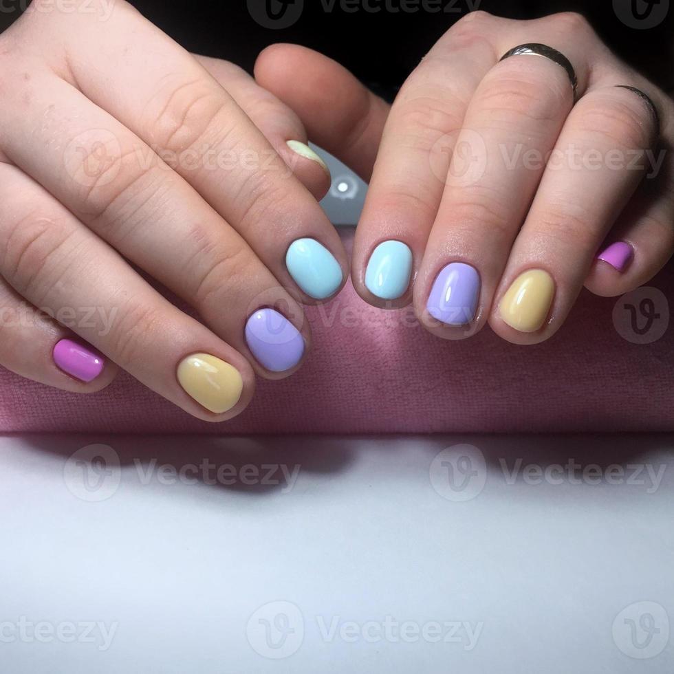 manucure de différentes couleurs sur les ongles. manucure féminine sur la main photo