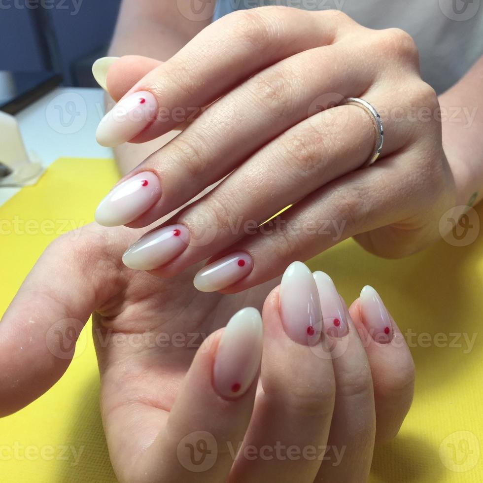 manucure de différentes couleurs sur les ongles. manucure féminine sur la main sur fond jaune photo