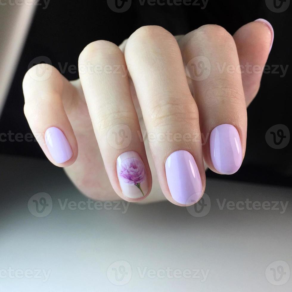 manucure rose féminine à la mode élégante. mains d'une femme avec manucure rose sur les ongles photo