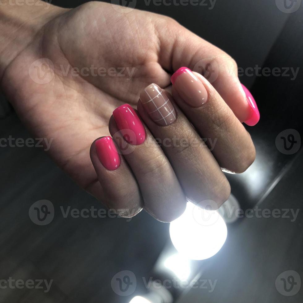 manucure rose féminine à la mode élégante. mains d'une femme avec manucure rose sur les ongles photo