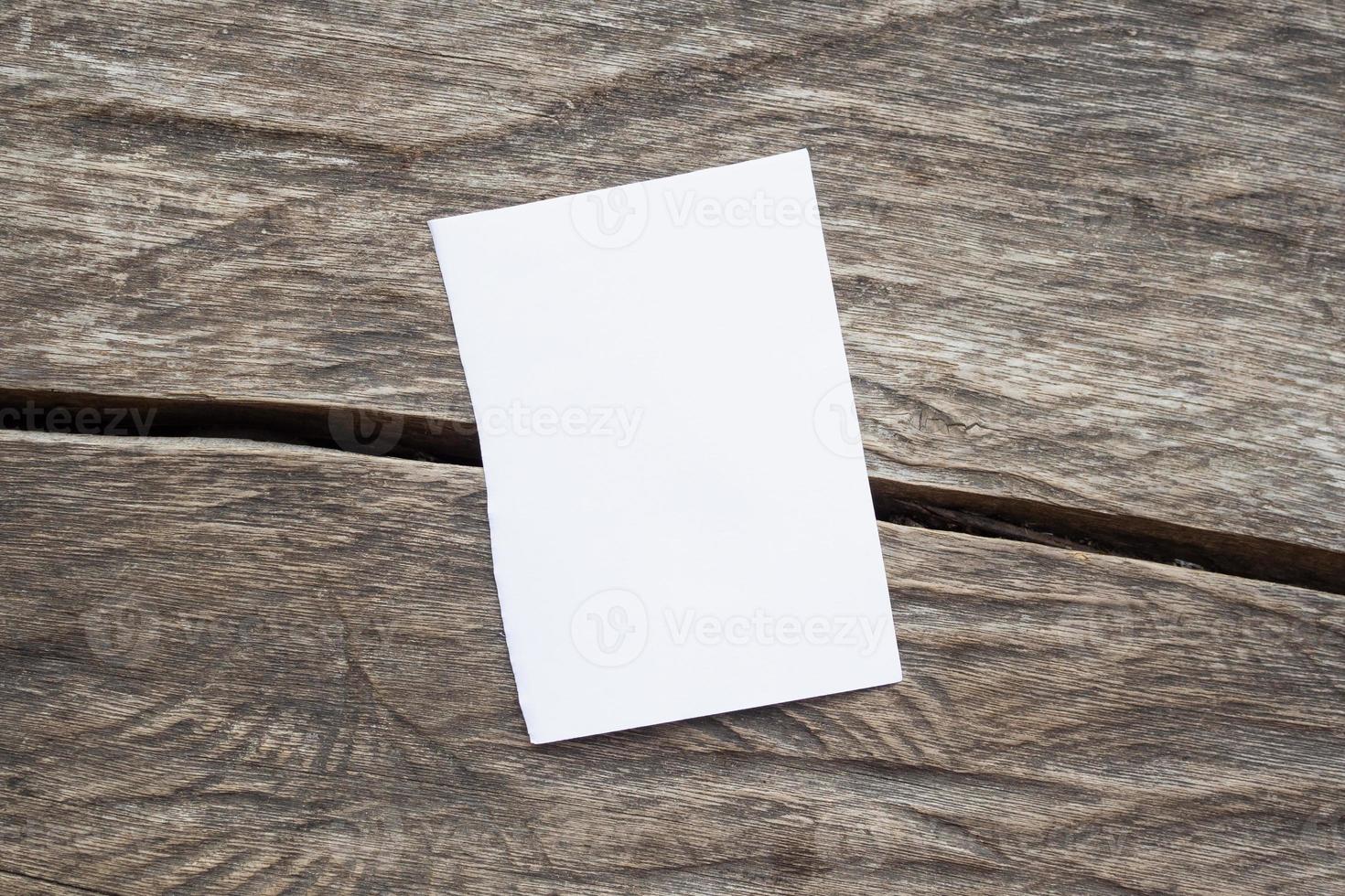 papier blanc vierge sur le vieux fond de table en bois rustique photo