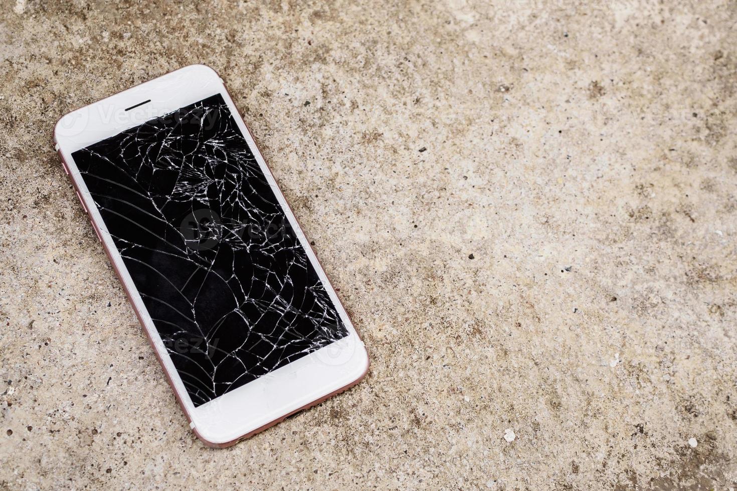 verre brisé d'écran de téléphone portable sur fond de sol en béton photo