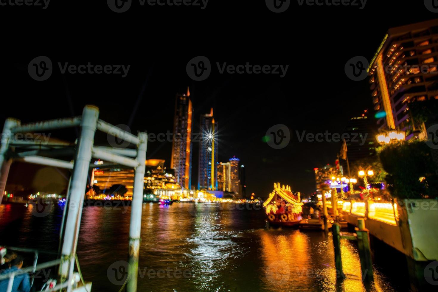 flou de la scène nocturne de la rivière chao phraya avec le paysage urbain de bangkok, thaïlande photo