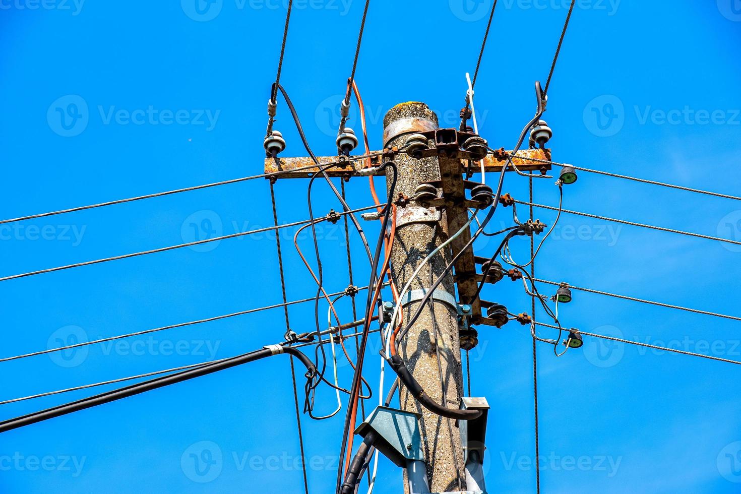 lignes électriques de poteau électrique fils électriques sortants contre le ciel bleu nuageux. photo