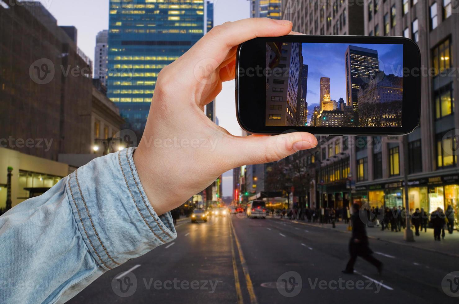 touriste prenant une photo de la ville de new york la nuit