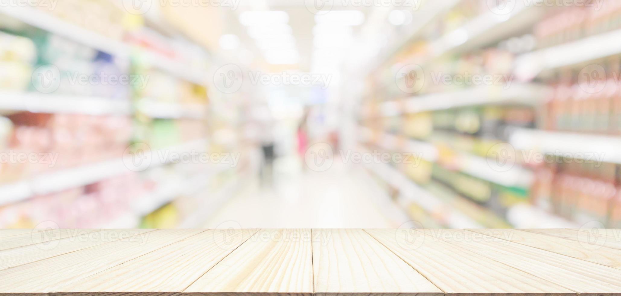 dessus de table en bois avec allée de supermarché avec client flou défocalisé étagères de produits bokeh intérieur fond clair photo