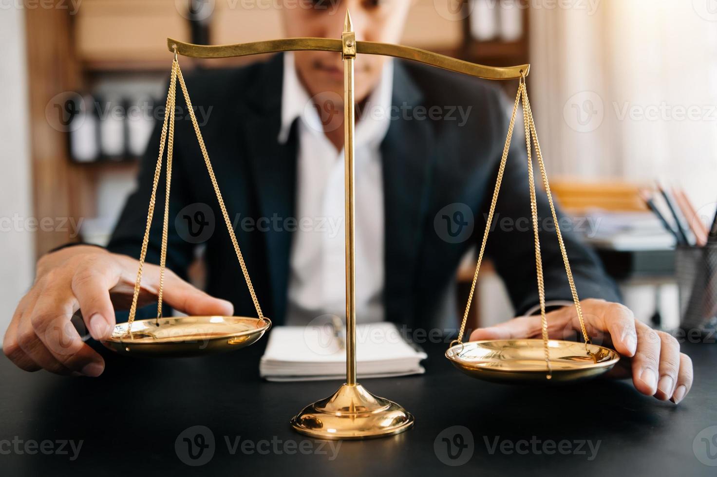 avocat masculin au bureau avec échelle en laiton sur table en bois. concept de justice et de droit à la lumière du matin photo