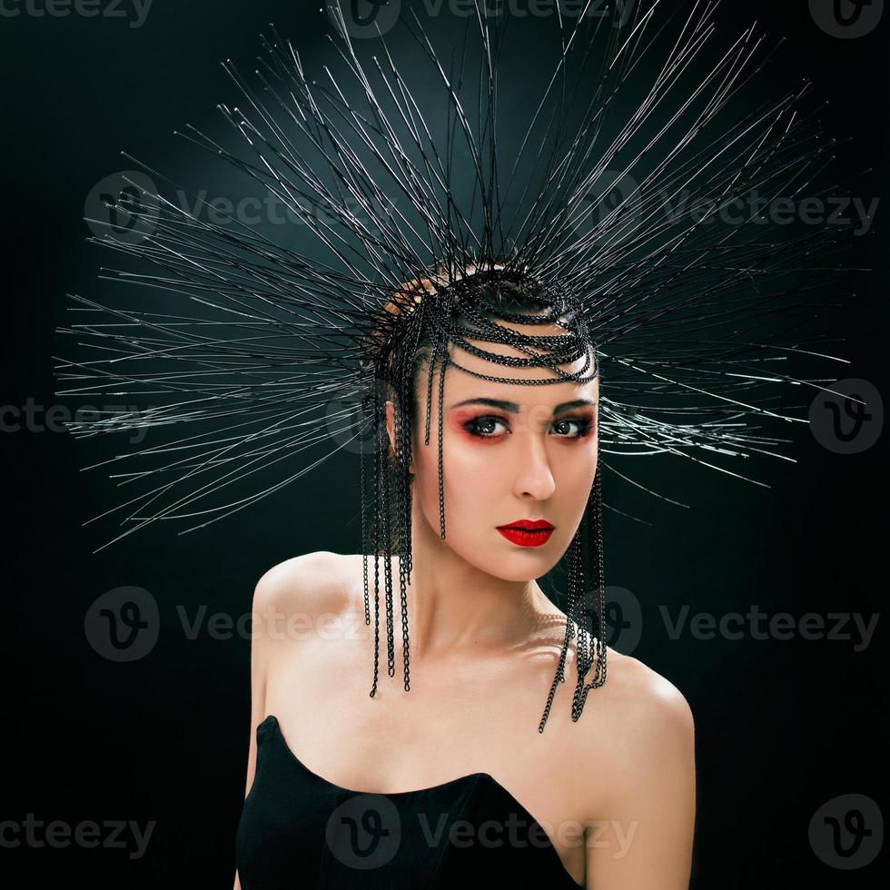 portrait d'une belle jeune femme comme une sorcière avec des lèvres rouges et une couronne noire sur fond sombre. beauté noire noire, concept d'halloween photo