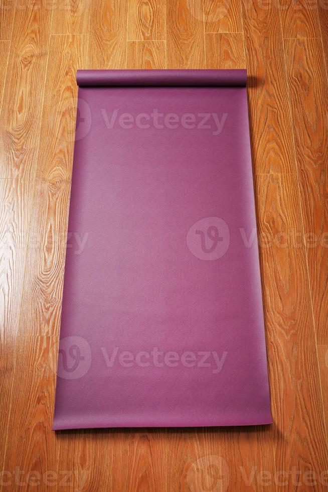 un tapis de yoga de couleur lilas est étalé sur le sol en bois avec une figurine de ganapati photo