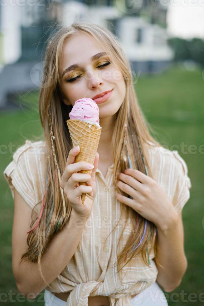 heureuse jeune fille tenant une glace et profitant d'une journée d'été photo