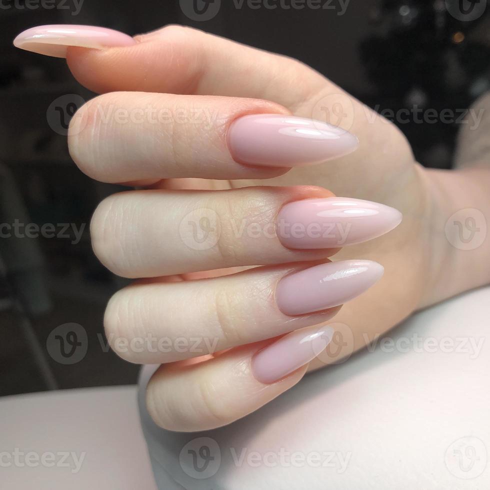 manucure rose féminine à la mode élégante. mains d'une femme avec manucure rose sur les ongles photo