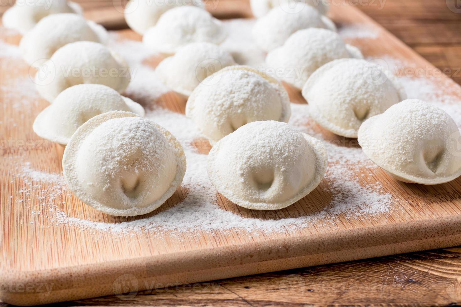 boulettes crues sur une planche à découper en bois dans la cuisine photo