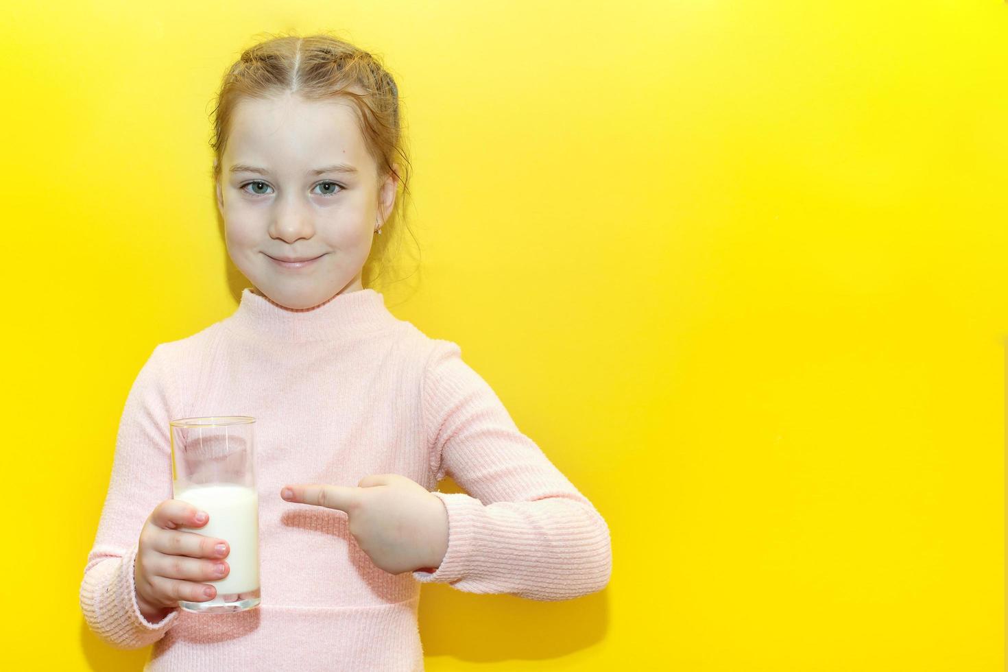 petite fille fille tenant un verre de lait photo