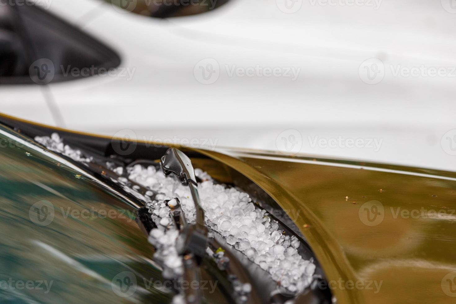 petites boules de glace de grêle sur un capot de voiture marron après une forte tempête estivale photo