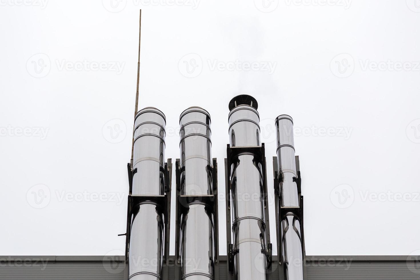 tuyaux de ventilation chromés sur le mur extérieur du bâtiment industriel blanc et bleu photo