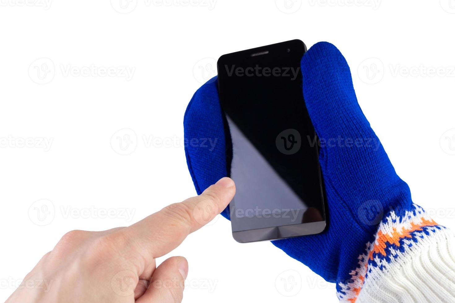 Doigt visant à téléphone portable avec mitaines blanc-bleu isolé sur fond blanc avec mise au point sélective photo