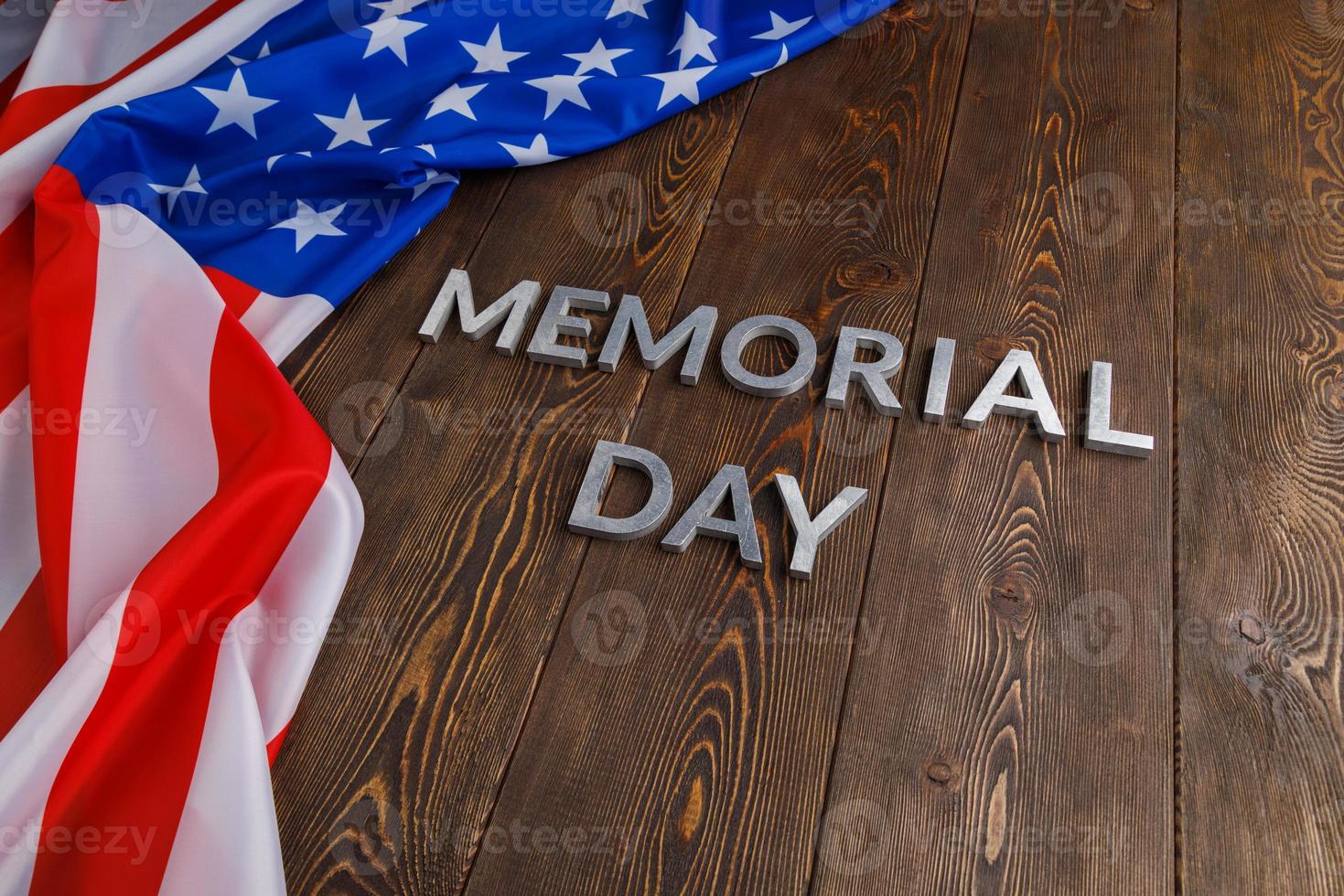 les mots jour du souvenir posés avec des lettres en métal argenté sur la surface de la planche de bois avec le drapeau usa froissé photo