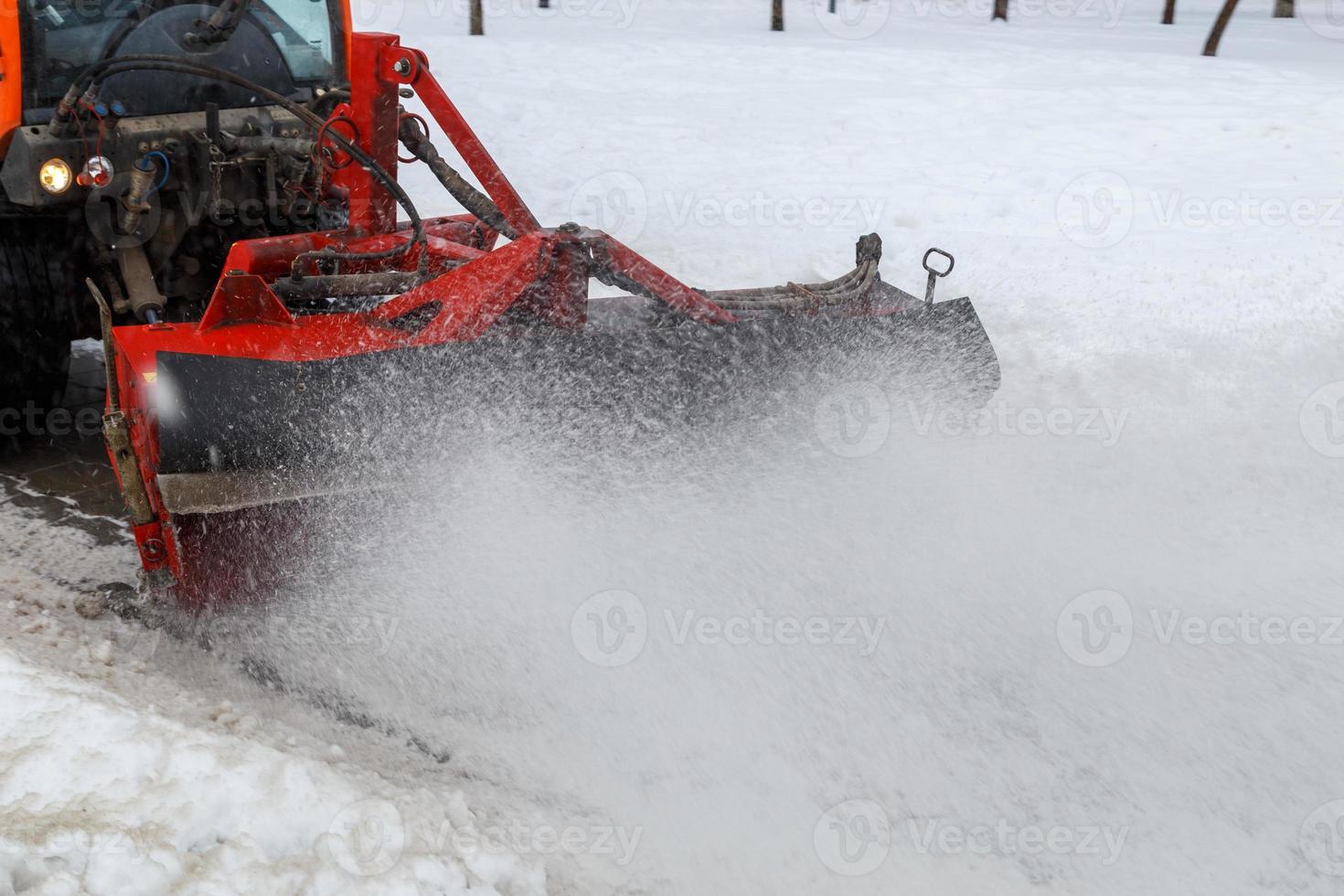 nettoyage de la neige. tracteur de déneigement enlevant la neige de la chaussée avec une brosse ronde spéciale, photo