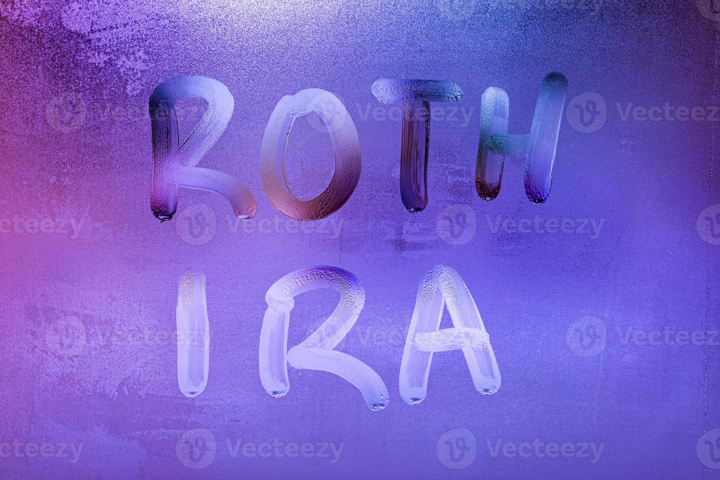 les mots roth ira - compte de retraite individuel - écrit à la main sur la surface en verre de la fenêtre humide de nuit photo