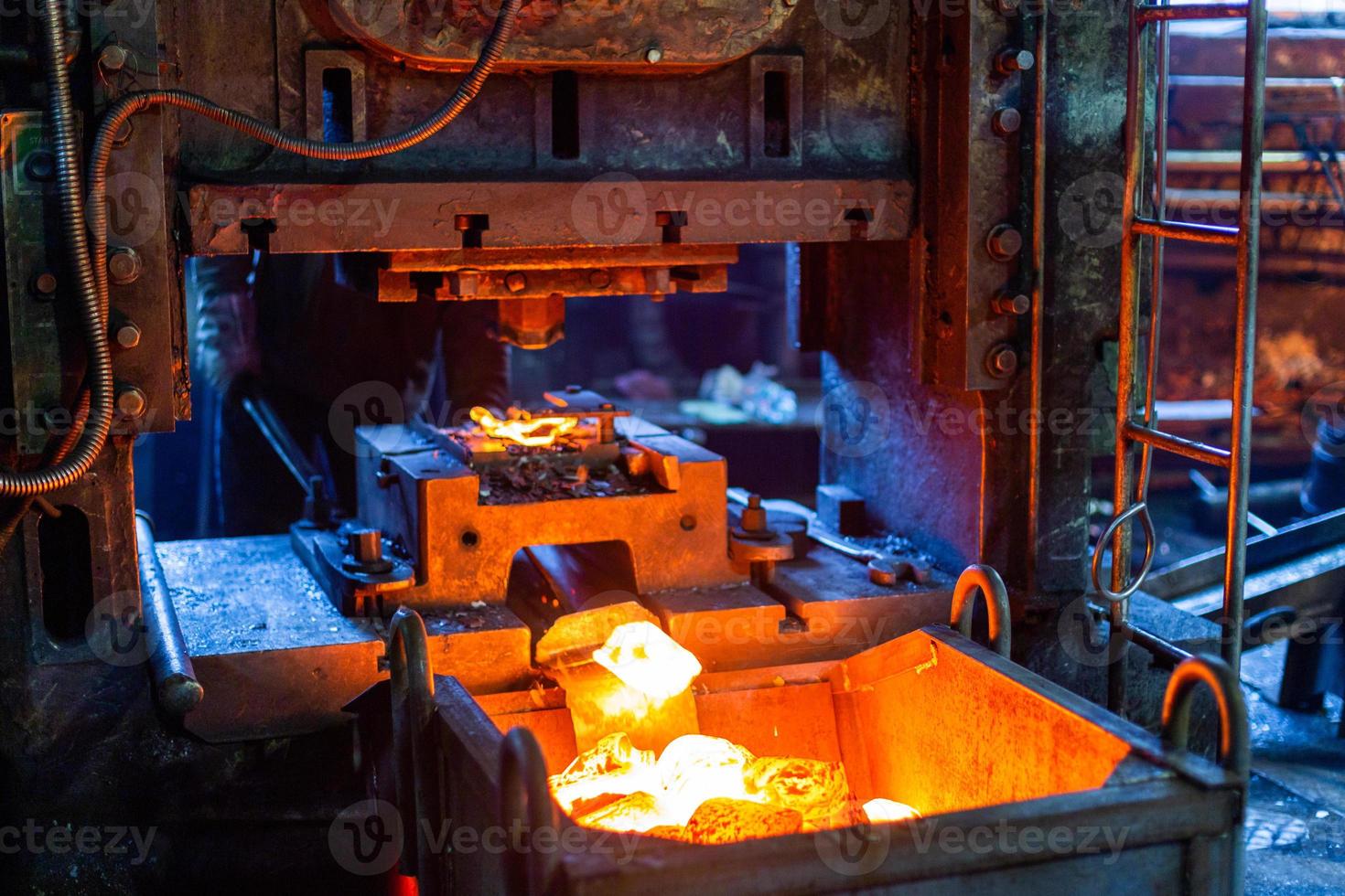 photo en gros plan de pièces en acier chaud fraîchement forgées après formage à la presse dans une usine sombre et sale