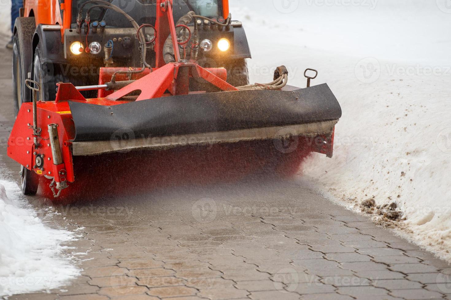 nettoyage de la neige. tracteur de déneigement enlevant la neige de la chaussée avec une brosse ronde spéciale, photo