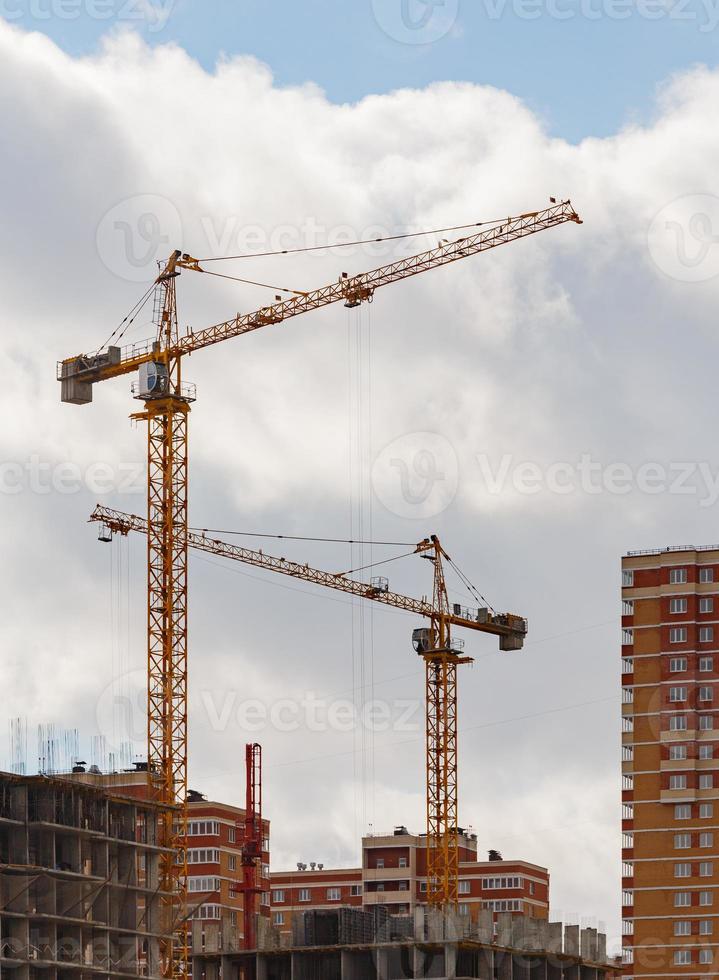 processus de construction d'un grand immeuble résidentiel avec grue sur fond de ciel nuageux photo
