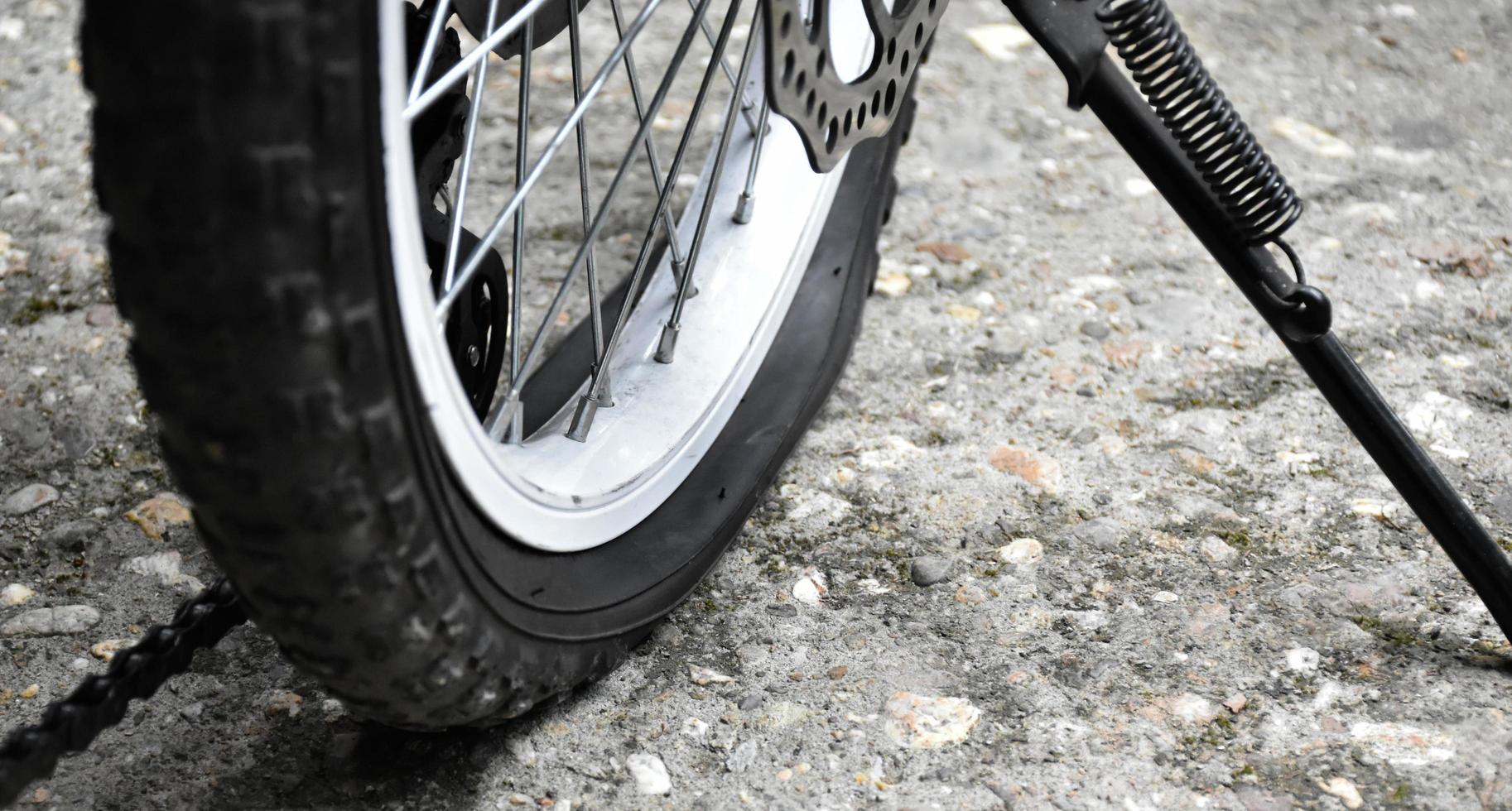 pneu crevé de vélo garé sur un sol en ciment, mise au point douce et sélective. photo