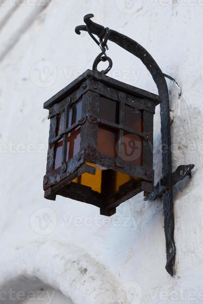 Lampe de rue en fer forgé sur mur de briques en stuc blanc mise au point sélective gros plan photo