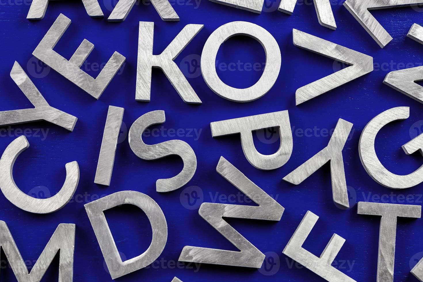 abstrait plat de caractères de l'alphabet anglais en métal argenté sur fond bleu fantôme. photo