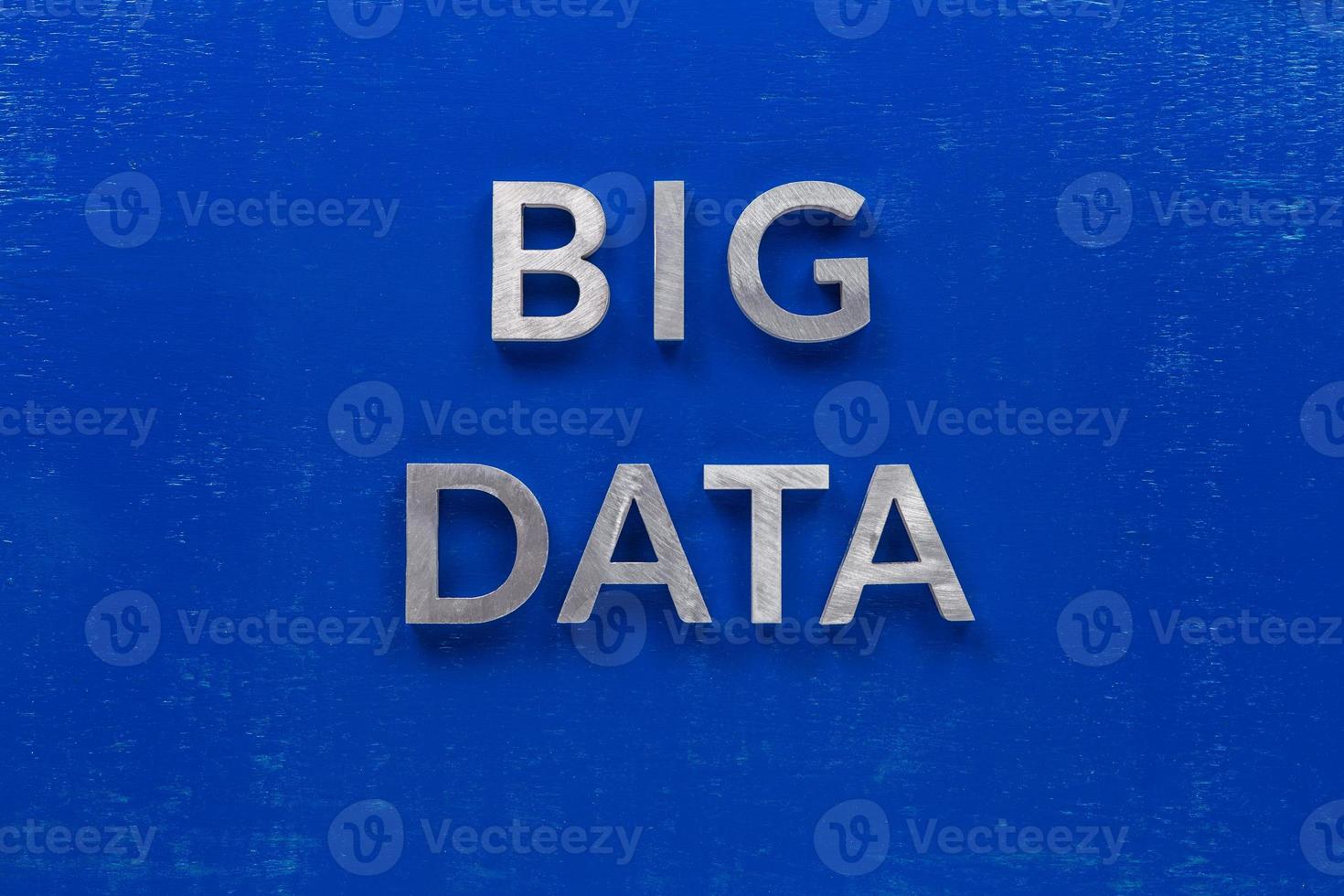 les mots big data posés avec des caractères en métal argenté sur une planche en bois peinte en bleu dans la composition centrale à plat photo