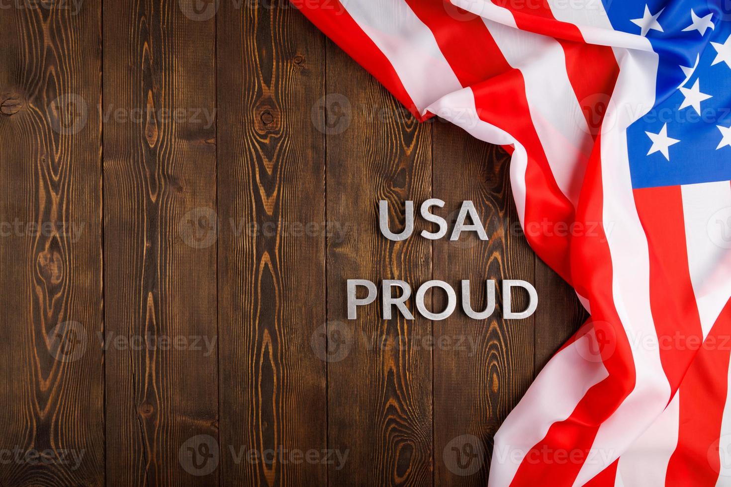 mots usa fiers posés avec des lettres en métal argenté sur une surface en bois marron avec le drapeau des états-unis d'amérique photo