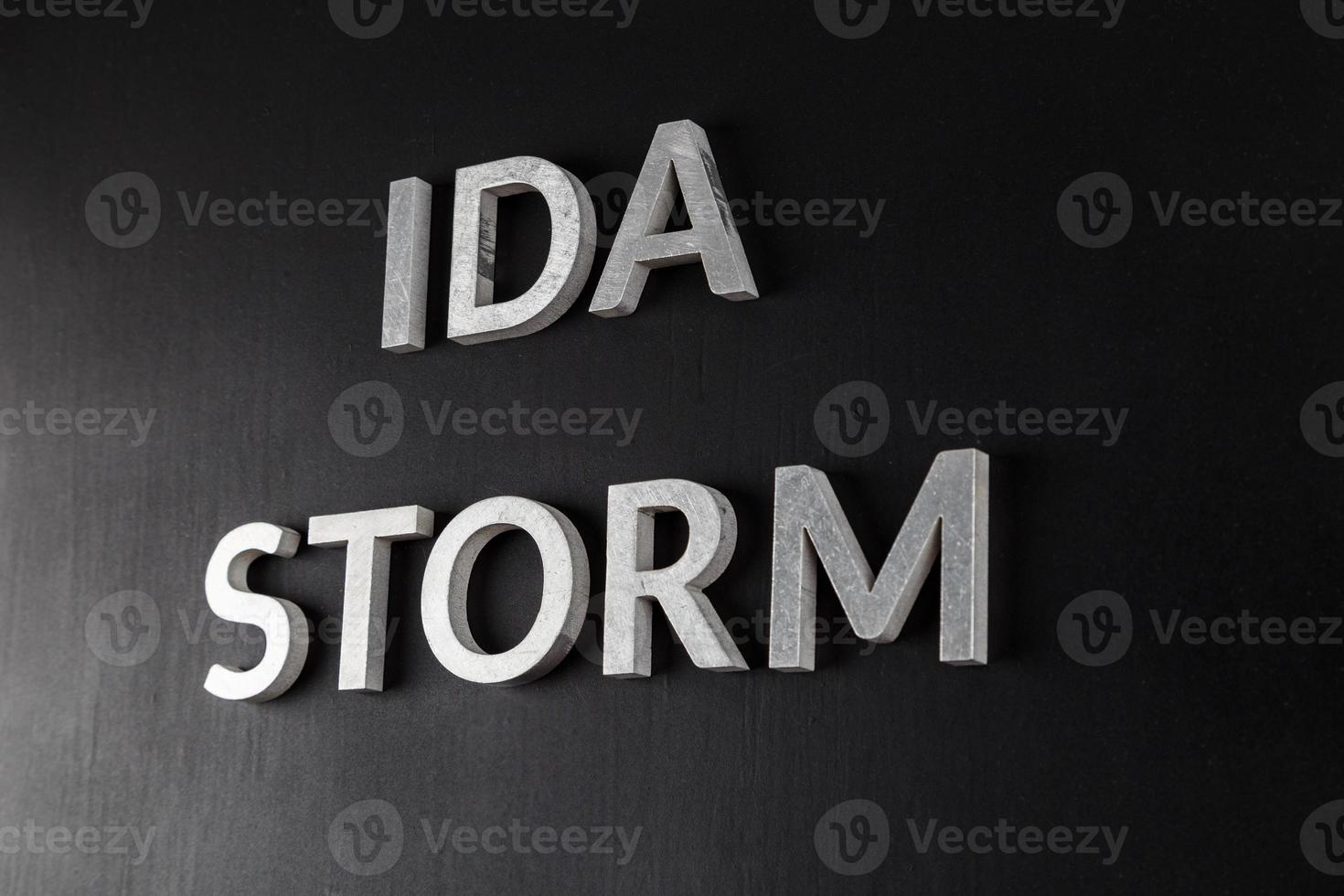 mots ida storm posés avec des lettres en métal argenté sur une surface mate noire sèche photo