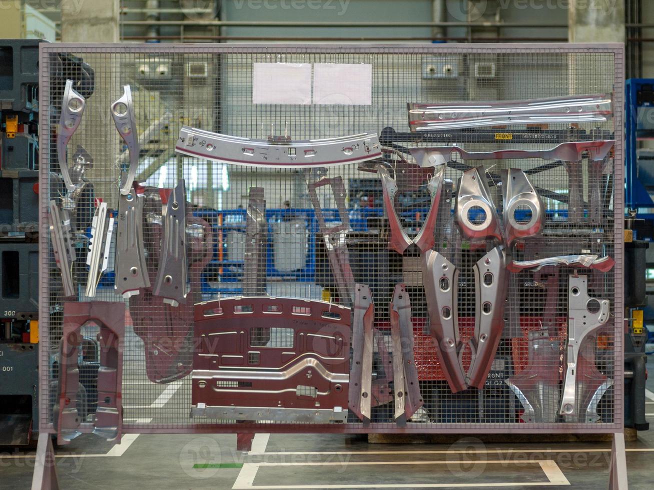 Pièces formées en tôle industrielle automobile sur grille en acier dans l'atelier d'emboutissage de l'usine photo