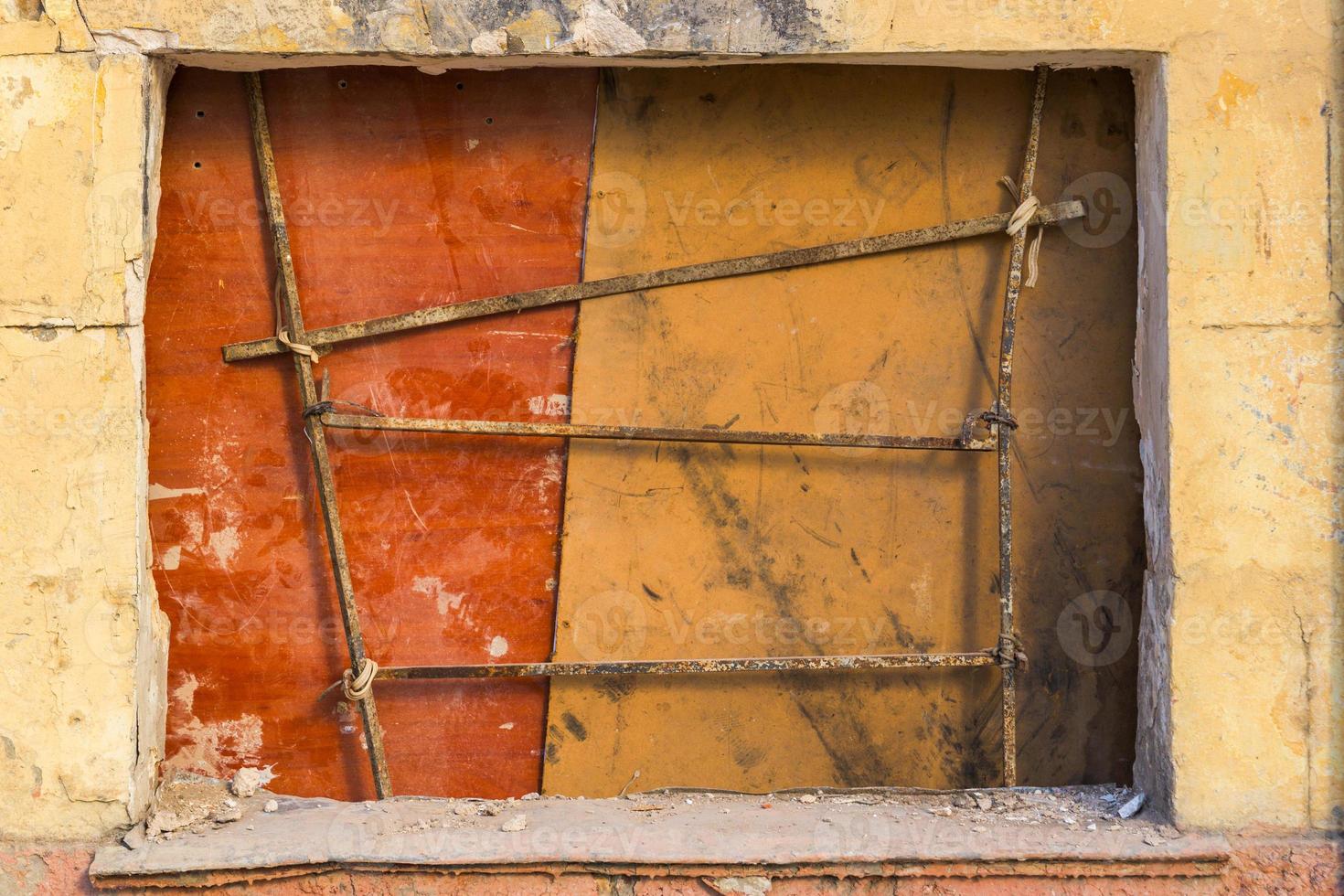 mur jaune avec grille de fenêtre photo