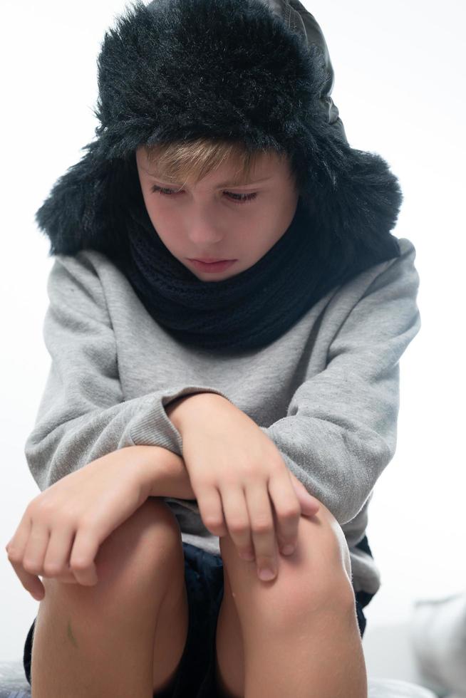 portrait d'un gars bouleversé en bonnet et écharpe d'hiver, hiver froid et temps de crise. photo