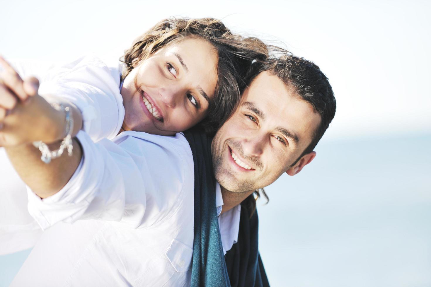 heureux jeune couple s'amuser sur la belle plage photo