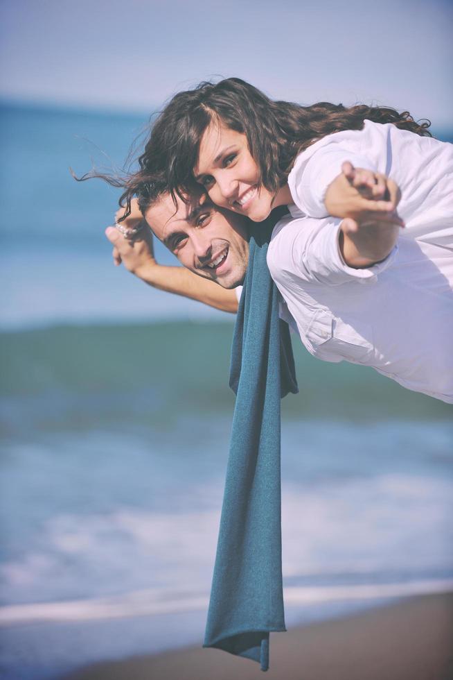 heureux jeune couple s'amuser sur la belle plage photo