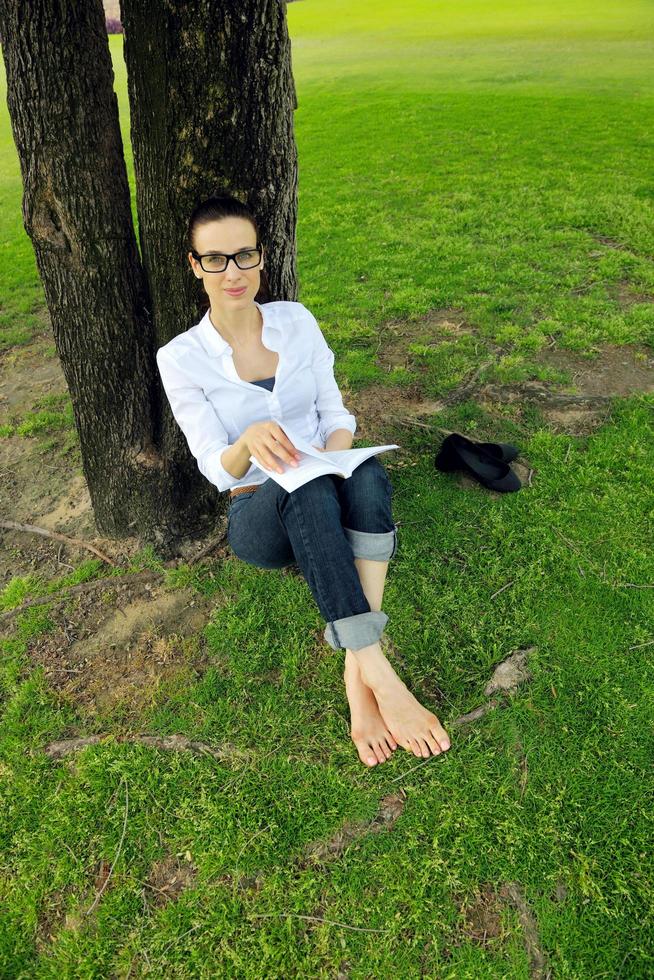 jeune femme lisant un livre dans le parc photo