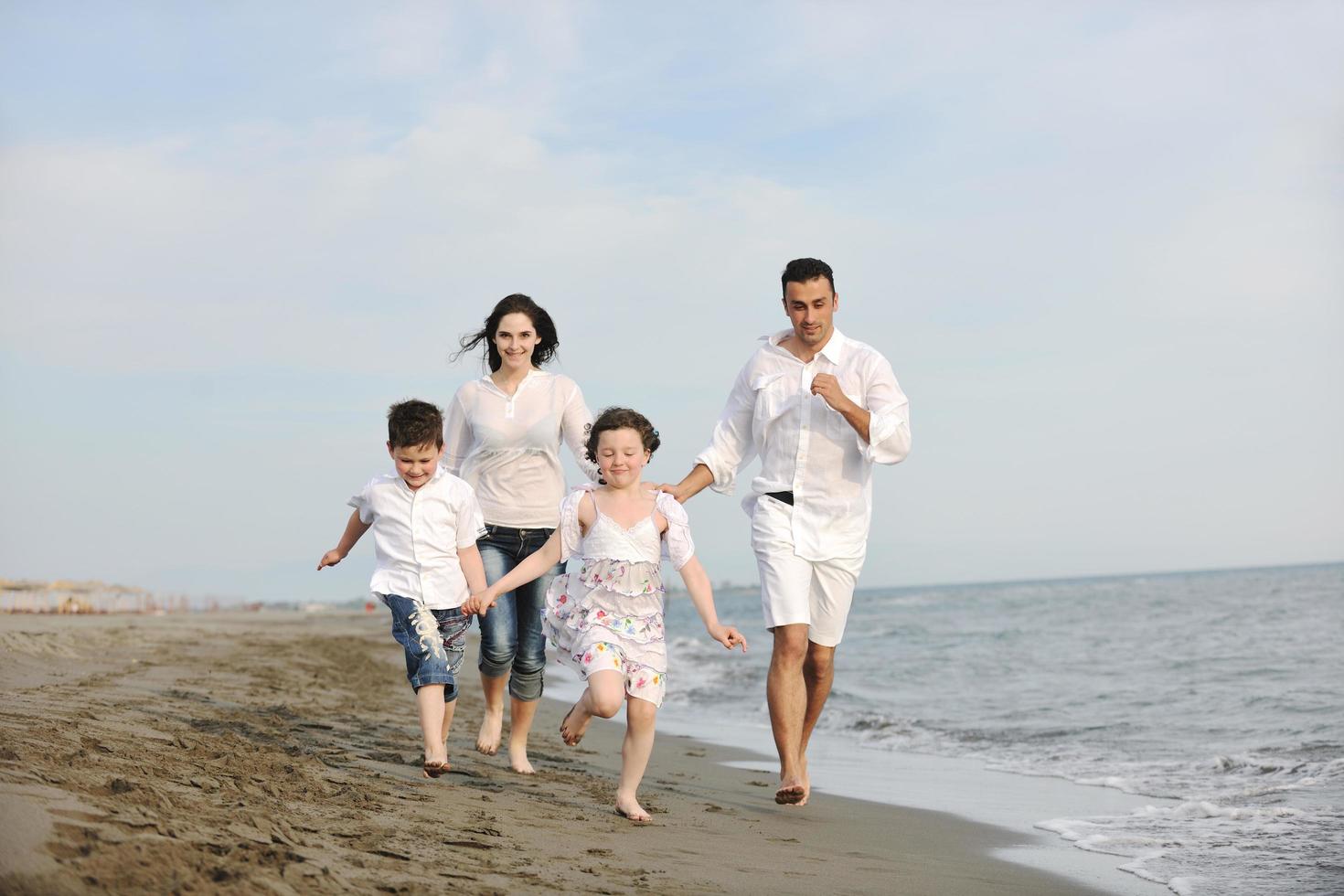 jeune famille heureuse s'amuser sur la plage photo