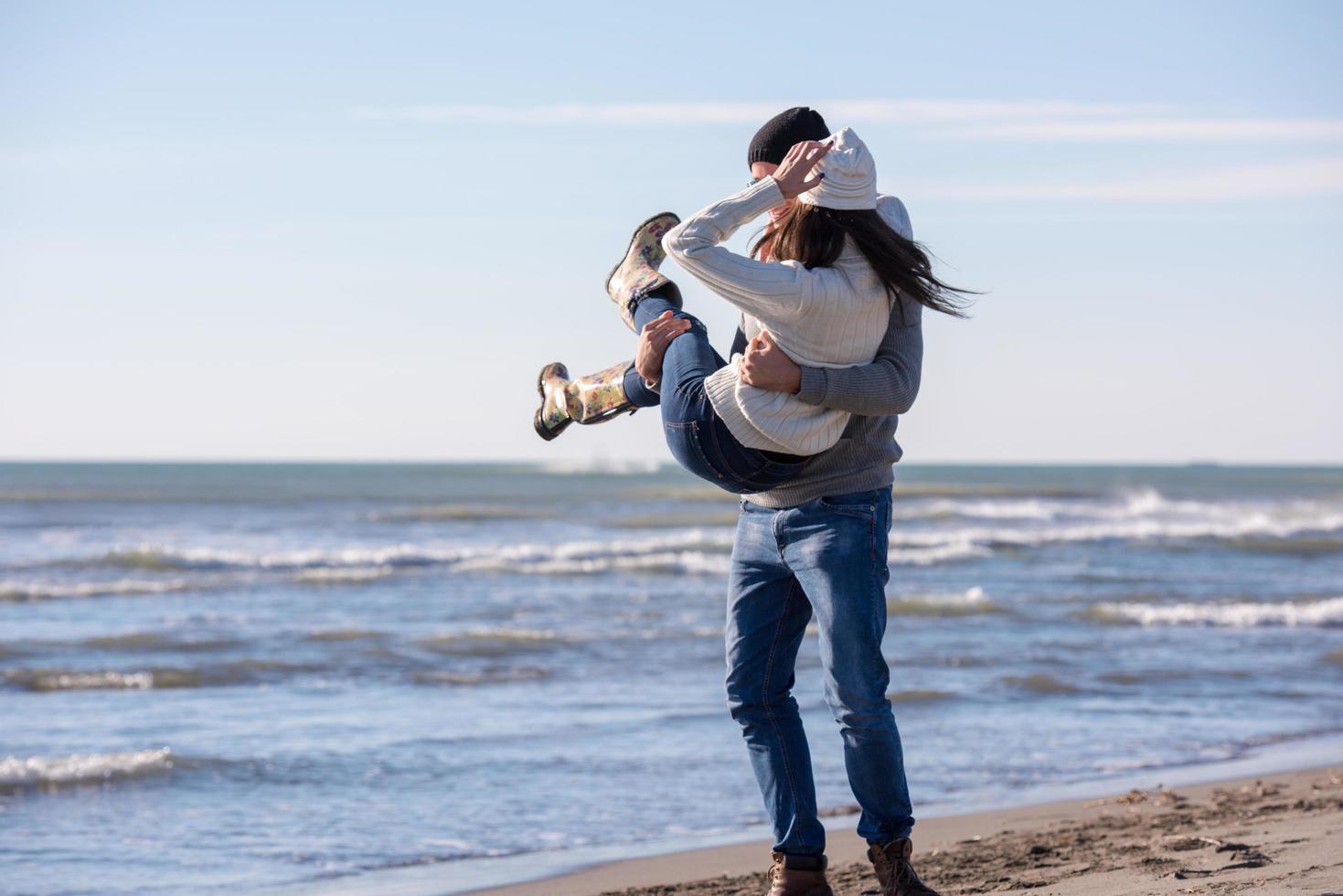 jeune couple aimant sur une plage à la journée ensoleillée d'automne photo